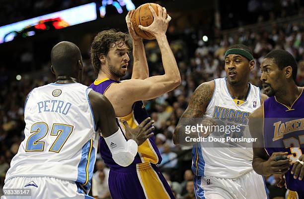 Pau Gasol of the Los Angeles Lakers controls the ball as Johan Petro of the Denver Nuggets defends while Carmelo Anthony of the Nuggets defends...
