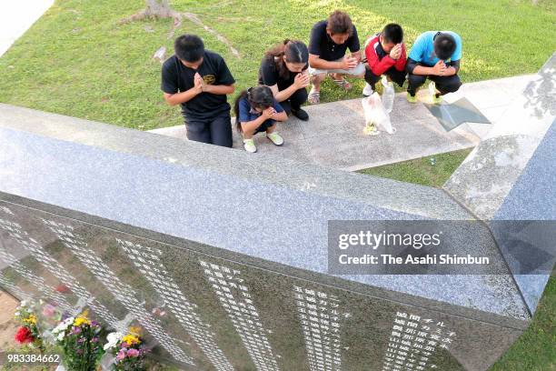 People pray for the victims at the Cornerstone of Peace where the names of their bereaved family members and relatives engraved at the Peace Memorial...