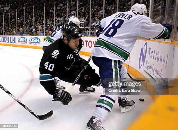 Kent Huskins of the San Jose Sharks falls to the ice as Steve Bernier of the Vancouver Canucks takes the puck at HP Pavilion on April 8, 2010 in San...