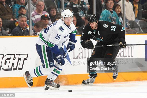 Mikael Samuelsson of the Vancouver Canucks carries the puck against Joe Thornton of the San Jose Sharks during an NHL game on April 8, 2010 at HP...