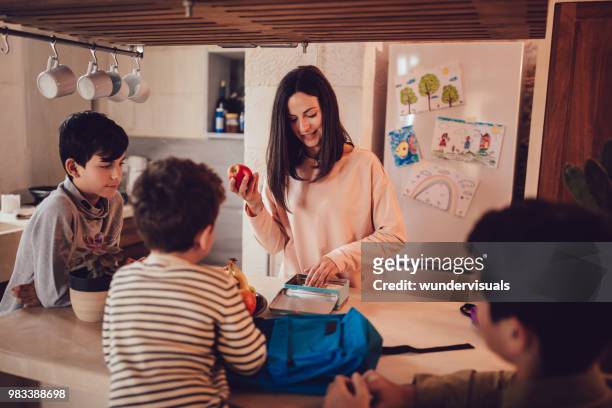 madre prepara scatole per il pranzo di cibo sano per i bambini in cucina - preparazione foto e immagini stock