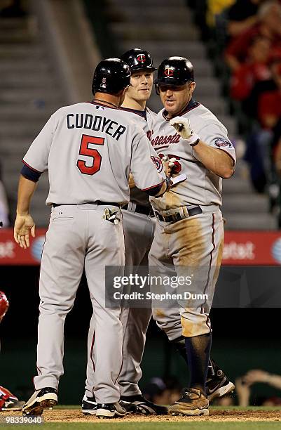 Jim Thome of the Minnesota Twins is greeted by Michael Cuddyer and Justin Morneau after they all score on Thome's three run home run in the eighth...