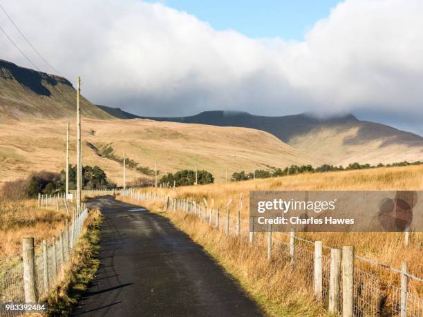 the road approaching the upper neuadd reservoir;pen y fan shrouded in cloud. image from a circular walk taking in the peaks of corn du and pen y fan in the brecon beacons national park, south wales, uk. january - pen y fan stock pictures, royalty-free photos & images