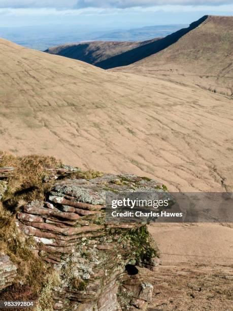 outcrop of sandstone rock and view to pen y fan. image from a circular walk taking in the peaks of corn du and pen y fan in the brecon beacons national park, south wales, uk. january - pen y fan stock pictures, royalty-free photos & images