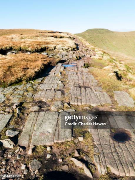 footpath on ridge of bedrock approaching corn du.image from a circular walk taking in the peaks of corn du and pen y fan in the brecon beacons national park, south wales, uk. january - pen y fan stock pictures, royalty-free photos & images