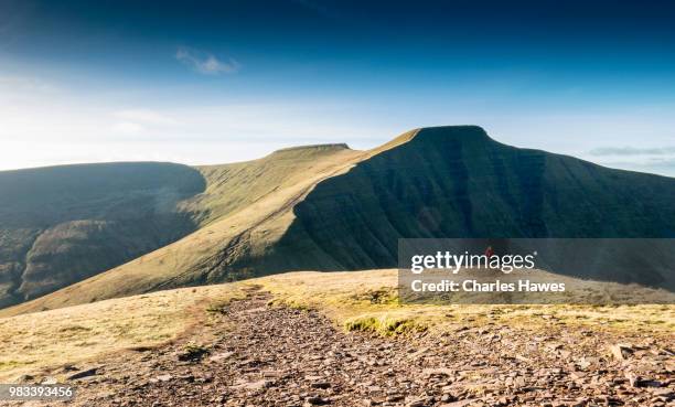 view to pen y fan and corn du from cribyn; one walker climbing hill. image from a circular walk taking in the peaks of corn du and pen y fan in the brecon beacons national park, south wales, uk. january - summit wales 2014 day 1 bildbanksfoton och bilder