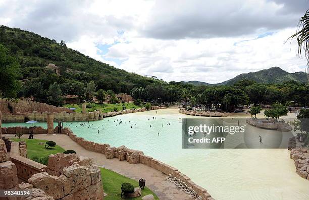 People swim in the artificial sandy beach of the Lost City water park in Sun City on February 22, 2010. The shaking walkway -- leading to a man-made...