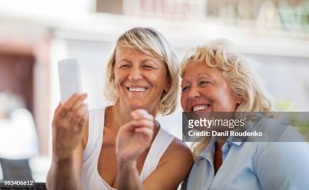 modern mature women making happy mobile selfie - happy mobile stockfoto's en -beelden
