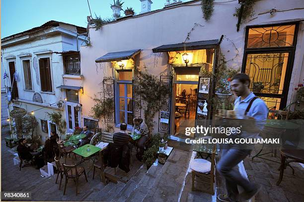 People sit in a cafe in Athens old Plaka district on April 8, 2010. AFP PHOTO/ LOUISA GOULIAMAKI