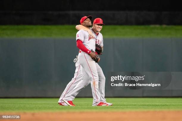 Mike Trout of the Los Angeles Angels laughs with Justin Upton against the Minnesota Twins on June 8, 2018 at Target Field in Minneapolis, Minnesota....