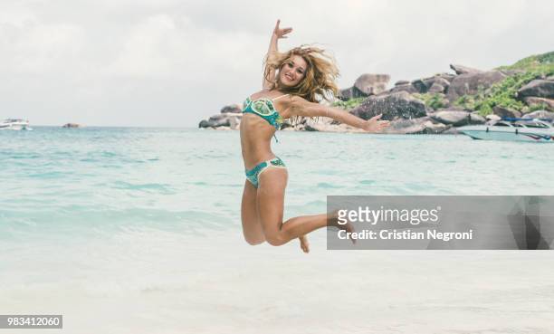 beautiful woman jumping on white sand beach - bikini atoll stockfoto's en -beelden