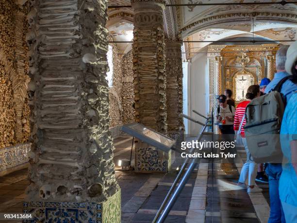 Tourists inside the Capela dos Ossos, a 16th century chapel built of human bones by a Franciscan monk, in Evora, Portugal. The monk wanted to...
