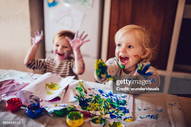 cheerful little children having fun doing finger painting - confusão imagens e fotografias de stock