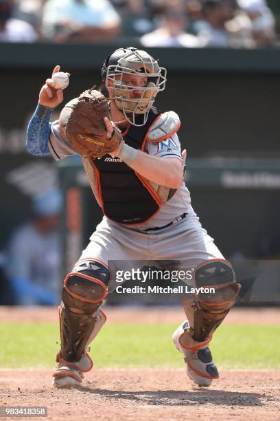 Bryan Holaday of the Miami Marlins looks to throw to second base during a baseball game against the Baltimore Orioles at Oriole Park at Camden Yards...
