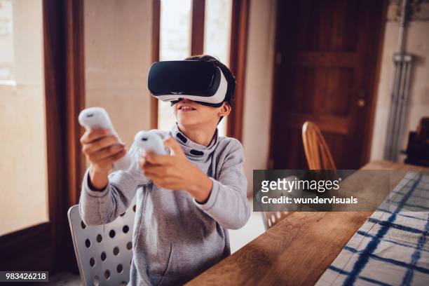 boy with virtual reality simulator playing augmented reality game - vr kids stock pictures, royalty-free photos & images