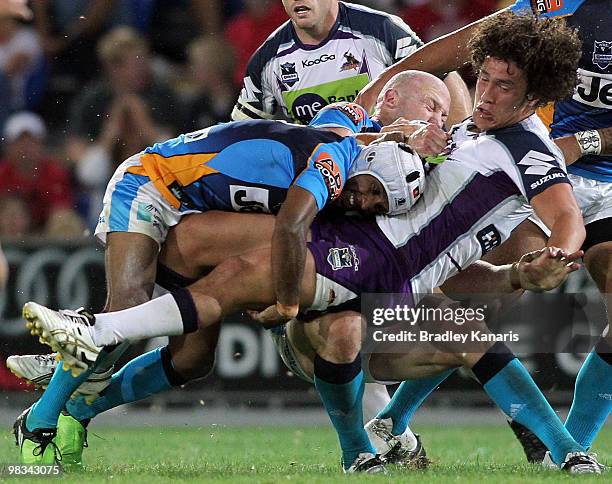 Kevin Proctor of the Storm is tackled during the round five NRL match between the Gold Coast Titans and the Melbourne Storm at Skilled Park on April...