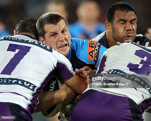 Greg Bird of the Titans is wrapped up by the Storm defence during the round five NRL match between the Gold Coast Titans and the Melbourne Storm at...