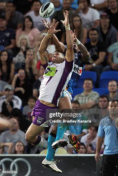 David Mead of the Titans and Greg Inglis of the Storm compete for the ball during the round five NRL match between the Gold Coast Titans and the...