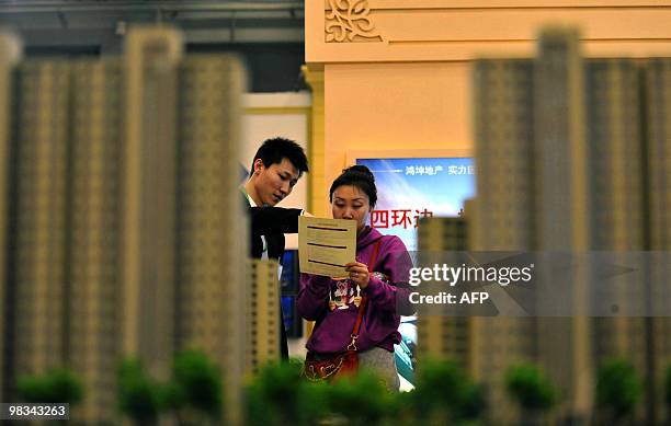 Chinese home buyers check out the new housing projects on offer at a property fair in Beijing on April 9, 2010. Soaring Chinese housing prices will...