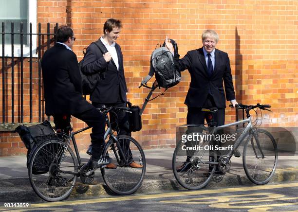 Boris Johnson , the Mayor of London, collects his bag from an assistant as he cycles following a visit to the Royal Hospital Chelsea on April 9, 2010...
