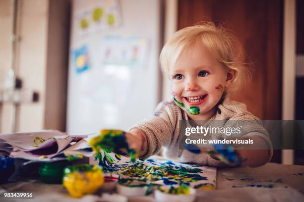 glückliches kleines kind spaß dabei fingermalerei zu hause - toddler mess stock-fotos und bilder