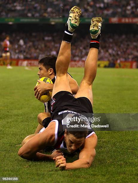 Paul Medhurst of the Magpies gathers the ball as Jason Blake of the Saints flies over the top of him during the round three AFL match between the St...