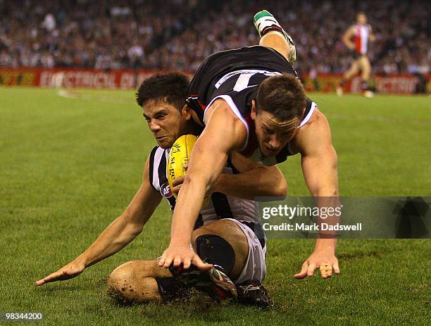 Paul Medhurst of the Magpies gathers the ball as Jason Blake of the Saints flies over the top of him during the round three AFL match between the St...