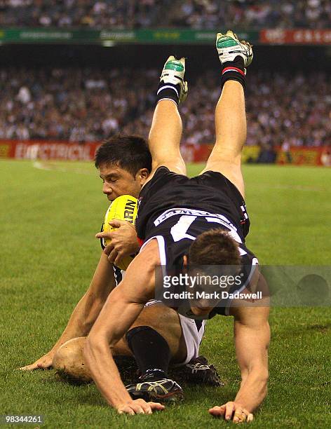 Paul Medhurst of the Magpies gathers the ball as Jason Blake of the Saints flies over the top of him during the round three AFL match between the St...
