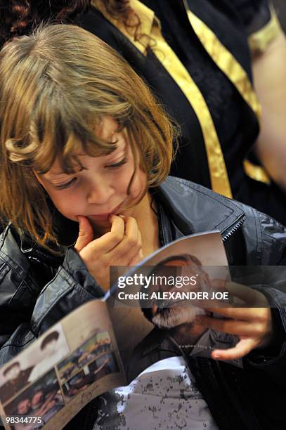 Girl reads a booklet with a picture of Afrikaner Resistance Movement leader Eugene Terre'Blanche during his funeral in Ventersdorp on April 9, 2010....