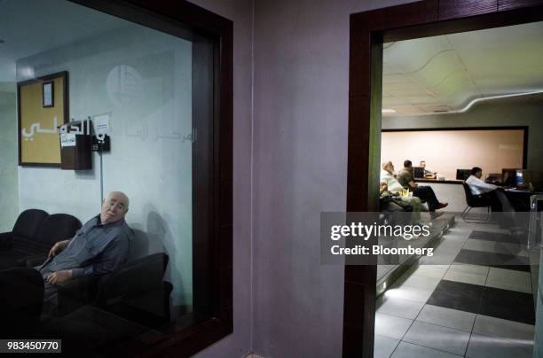 Investors watch trading screens at the International Financial Center at the Housing Bank Complex in Amman, Jordan, on Thursday, June 21, 2018....