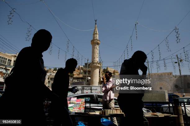 Men and women pass a street vendor in Amman, Jordan, on Thursday, June 21, 2018. President Trump and First Lady Melania Trump will host Jordans King...