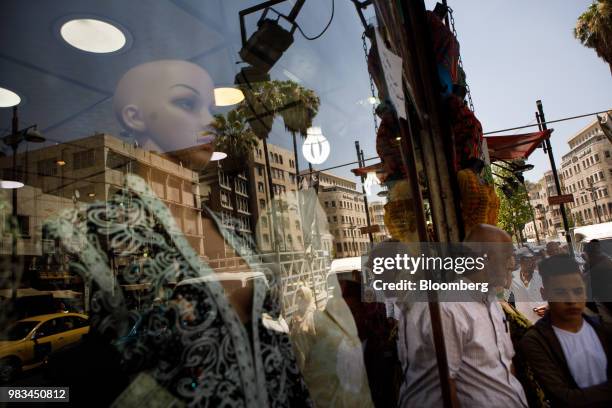 Pedestrians stand outside a women's fashion store in Amman, Jordan, on Thursday, June 21, 2018. President Trump and First Lady Melania Trump will...