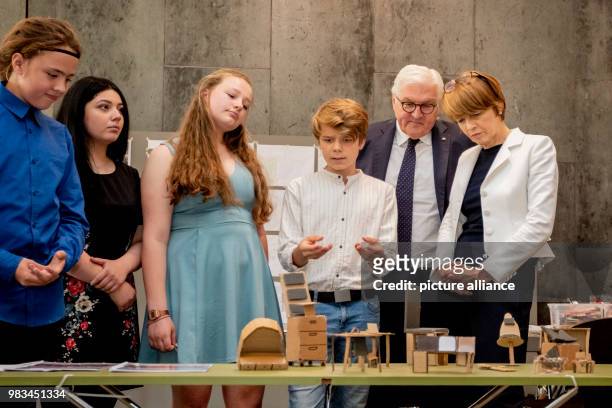 June 2018, Germany, Berlin: German President Frank-Walter Steinmeier and his wife Elke Buedenbender listening to an explanation by students from...