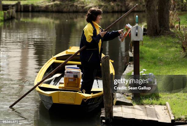 Jutta Pudenz, an employee of German postal carrier Deutsche Post DHL, arrives to deliver mail from her falt-bottomed canoe in the narrow canals in...