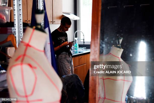 Student at the Casa 93 fashion school looks at her mobile phone on June 15 in Saint-Denis near Paris