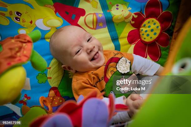 happy smiling baby boy playing in colorful playpen - playpen stock pictures, royalty-free photos & images