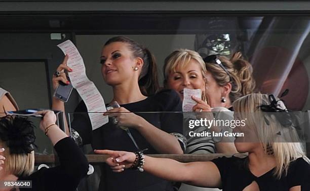 Coleen Rooney checks her betting slip after the first race during Ladies' Day at Aintree Racecourse on April 9, 2010 in Liverpool, England.