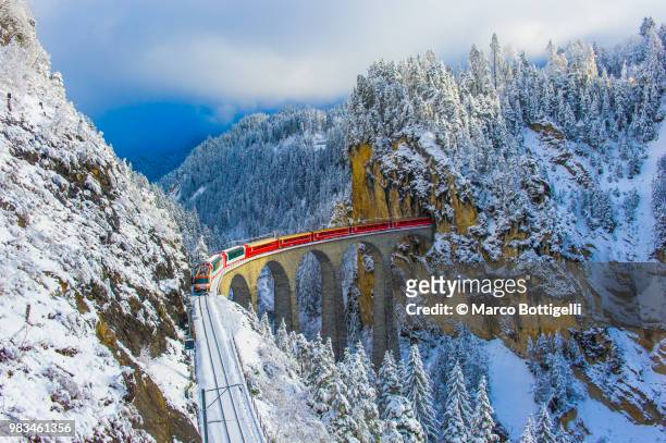 red train in winter wonderland - swiss culture ストックフォトと画像