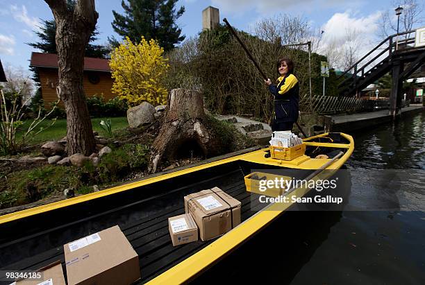 Jutta Pudenz, an employee of German postal carrier Deutsche Post DHL, navigates her falt-bottomed canoe through the narrow canals in the Spreewald...