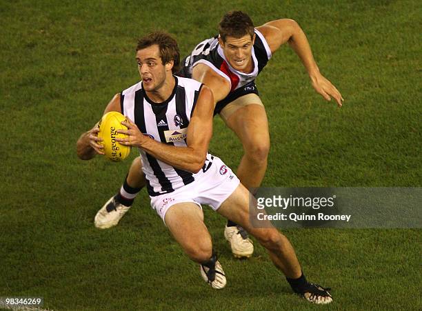 Alan Toovey of the Magpies avoids a tackle by Nick Dal Santo of the Saints during the round three AFL match between the St Kilda Saints and the...