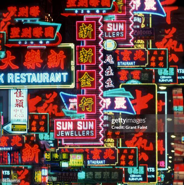 multiple neon shop signs in night composite image. - hong kong advertising stock pictures, royalty-free photos & images