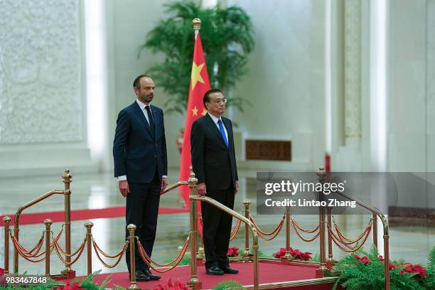 Chinese Premier Li Keqiang and French Prime Minister Edouard Philippe listen to their national anthems during a welcoming ceremony inside the Great...