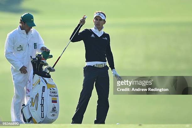 Camilo Villegas of Colombia pulls a club from his bag alongside caddie Brett Waldman during the second round of the 2010 Masters Tournament at...