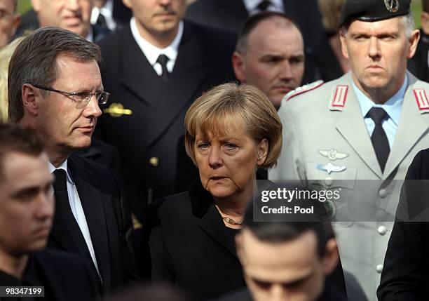 Lower Saxony Governor Christian Wulff stands next to German Chancellor Angela Merkel during a funeral service for three killed German ISAF soldiers...