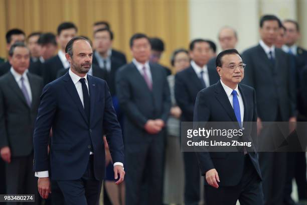 Chinese Premier Li Keqiang accompanies French Prime Minister Edouard Philippe as they review an honour guard during a welcoming ceremony inside the...