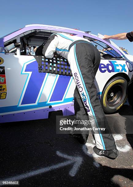 Denny Hamlin, driver of the FedEx Office/March of DimesToyota, climbs into his car during practice for the NASCAR Sprint Cup Series Subway Fresh Fit...