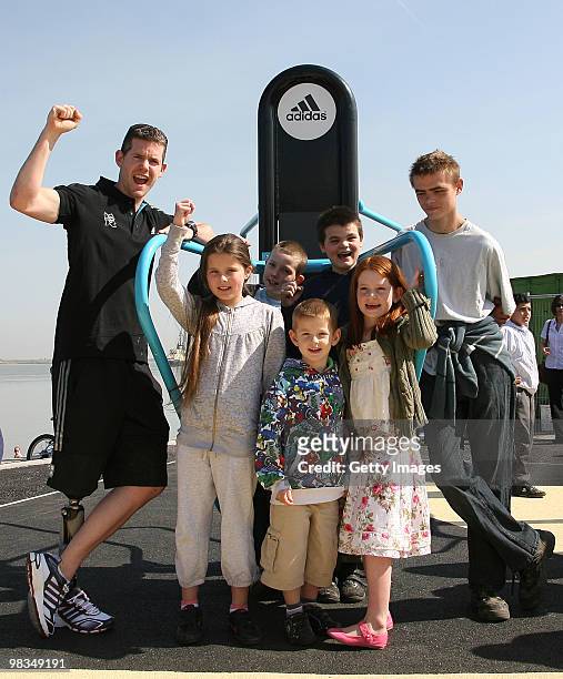 John McFall, member of Team GB, The British Olympic squad for 2012 and bronze medallist at the Beijing Olympics poses for a picture with local kids...