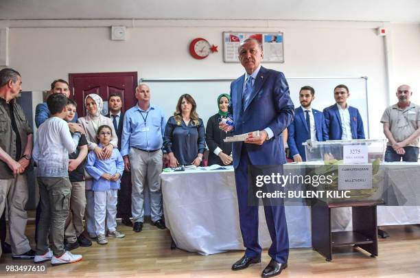 Turkey's President and leader of the Justice and Development Party Recep Tayyip Erdogan votes at a polling station after casting his vote during snap...