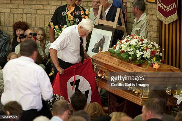 Andries TerreBlanche rolls up the AWB movement's flag during the funeral of Afrikaner Resistance Movement slain leader Eugene Terre'Blanche on April...