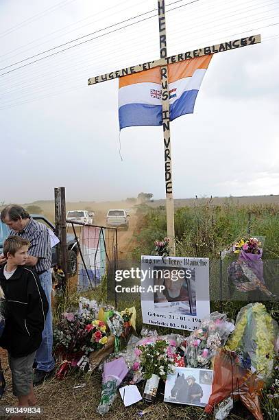 Supporters put flowers and an old South African flag at the gate leading to the farm where the Afrikaans Resistance Movement's leader Eugene...